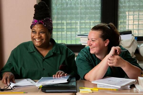 Two female students smiling in classroom