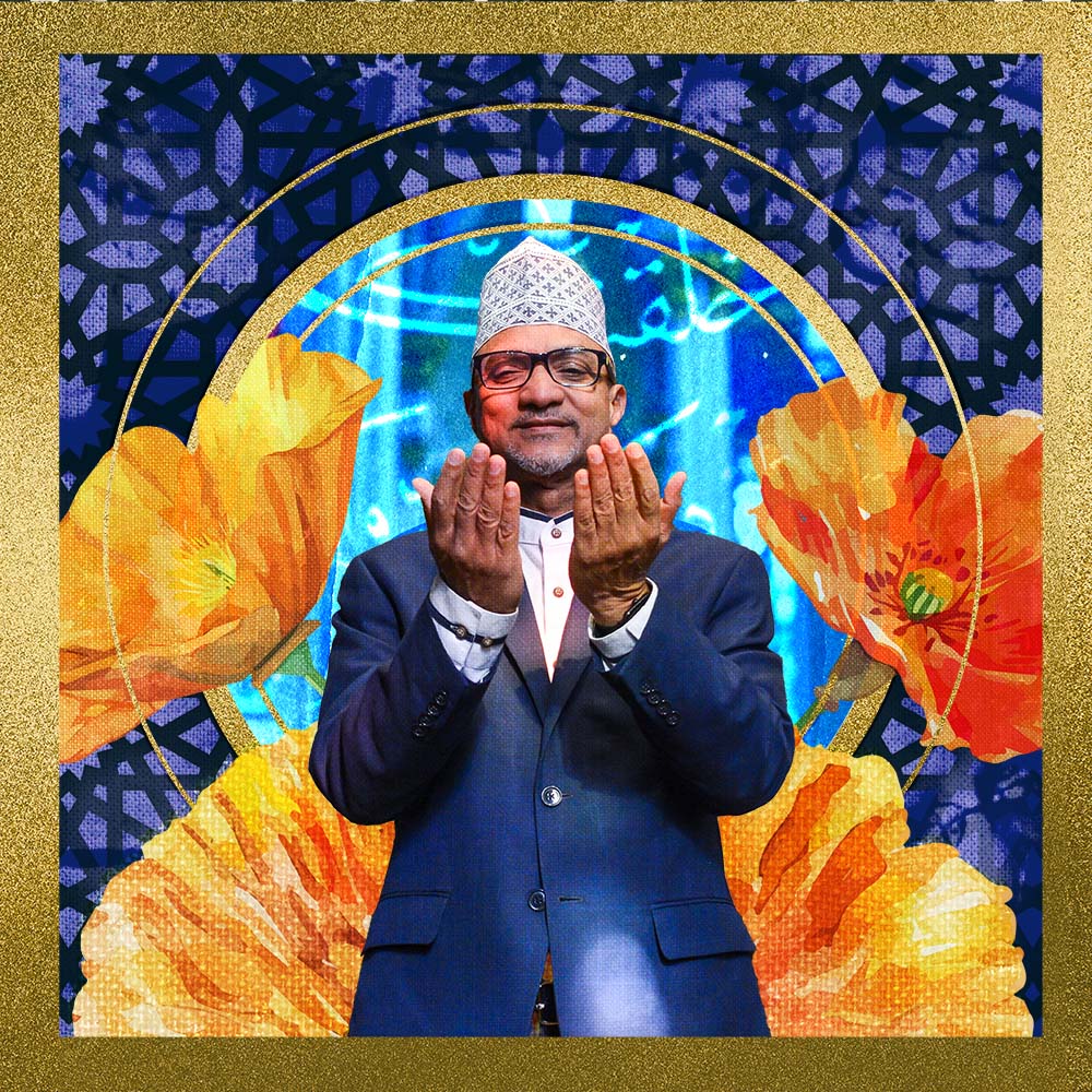 Rashied Omar wearing a blue suit, standing with hands in a gesture of prayer